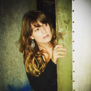 Lady looking around a door.