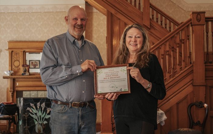 Two people standing in a house holding a plaque.